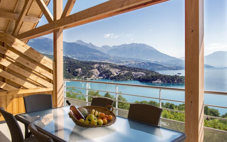 La vue depuis la terrasse de l'hébergement donne sur le lac et les montagnes.